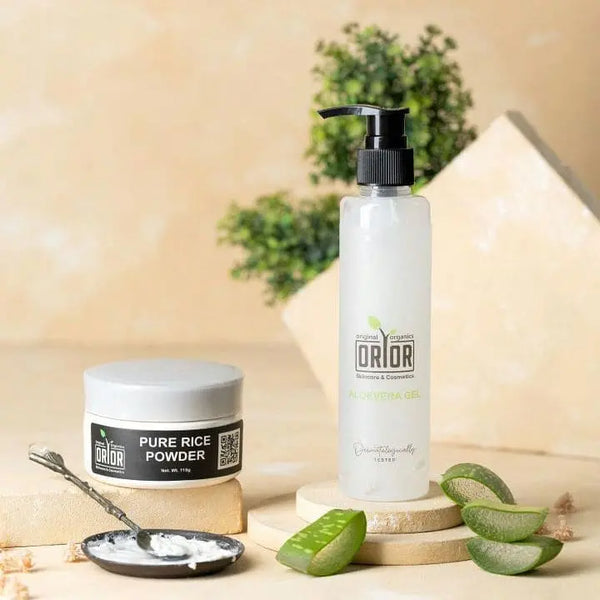 An arrangement featuring a bottle of aloe vera gel, a flat jar of rice powder, and a small plate containing a mixture of rice powder and aloe vera gel, stirred with a spoon. Additionally, four pieces of aloe vera are neatly displayed