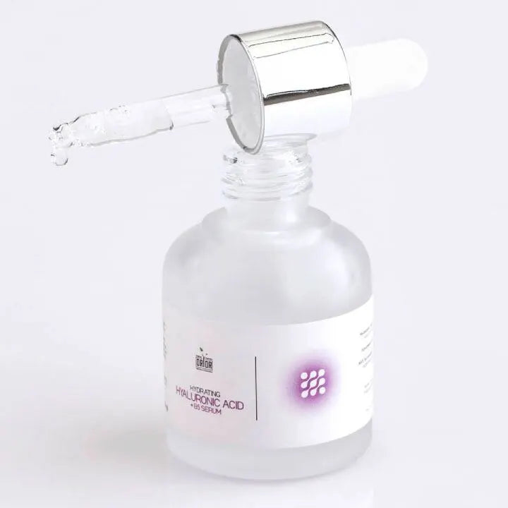 Hyaluronic Acid Serum with open dropper lid against white background. Here the dropper is on the bottle in  horizontal position and one drop of hyaluronic acid serum is dropping down