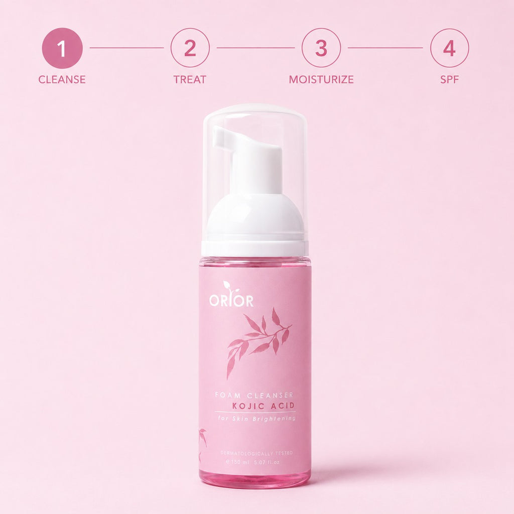 Orior Cosmetics Kojic Acid Foam Cleanser in a pink bottle with a pump dispenser against a soft pink background.